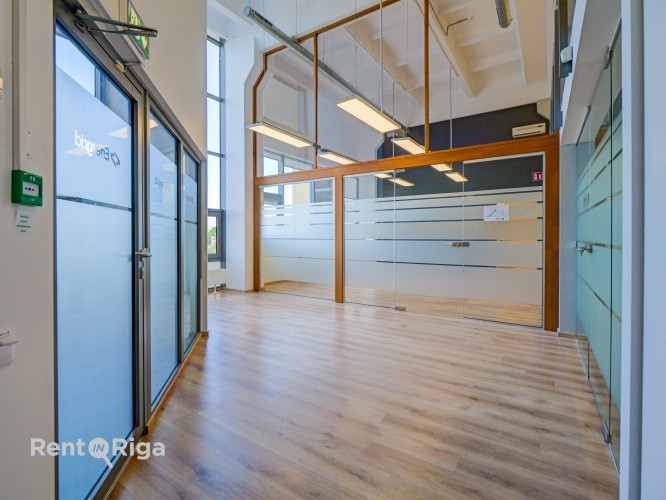 A spacious and bright loft-style office featuring an open-plan workspace and separate private office Рига - изображение 2