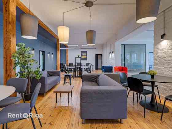 Office with a creative industrial atmosphere  high ceilings, wooden plank floors, exposed wooden bea Rīga