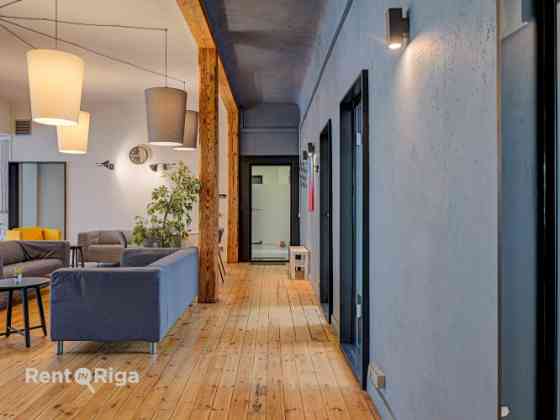 Office with a creative industrial atmosphere  high ceilings, wooden plank floors, exposed wooden bea Rīga