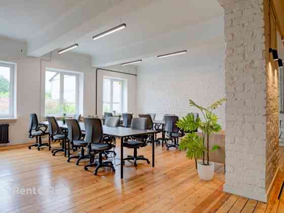 Office with a creative industrial atmosphere  high ceilings, wooden plank floors, exposed wooden bea Rīga