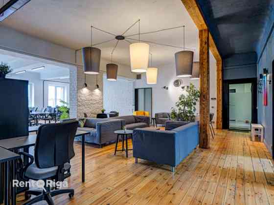 Office with a creative industrial atmosphere  high ceilings, wooden plank floors, exposed wooden bea Rīga