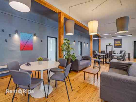 Office with a creative industrial atmosphere  high ceilings, wooden plank floors, exposed wooden bea Rīga